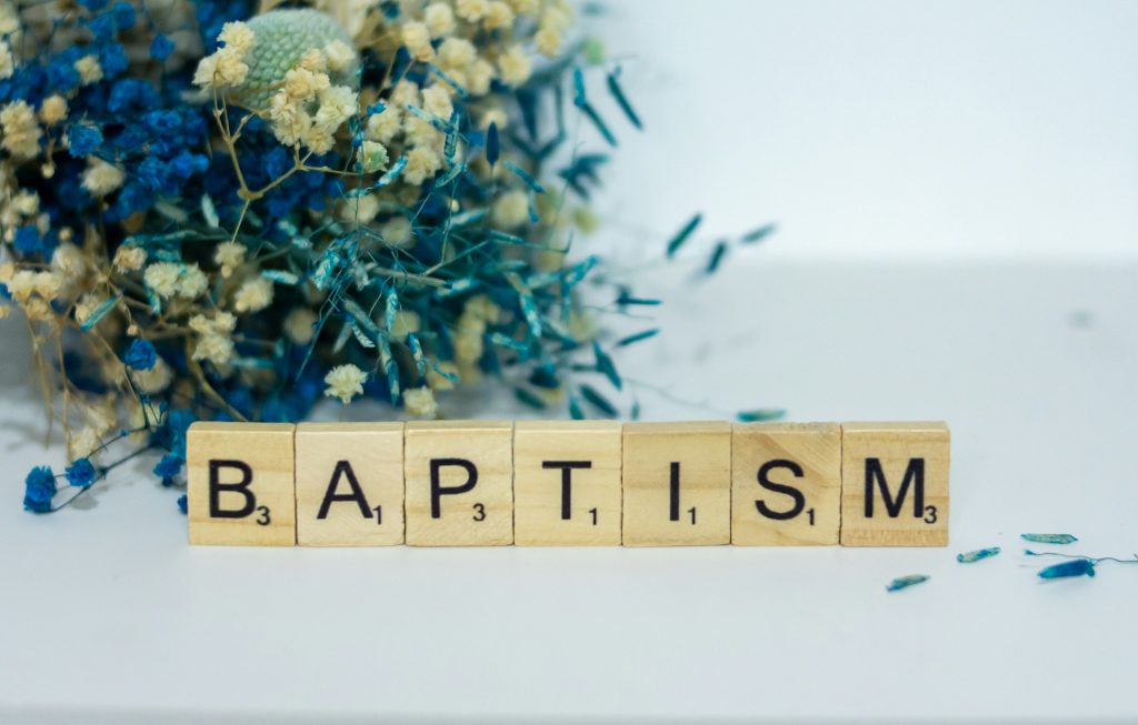 Flowers with the word "baptism" spelled with Scrabble tiles
